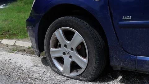 Close up slow motion shot of a car with a punctured flat tyre Video stock 154227958