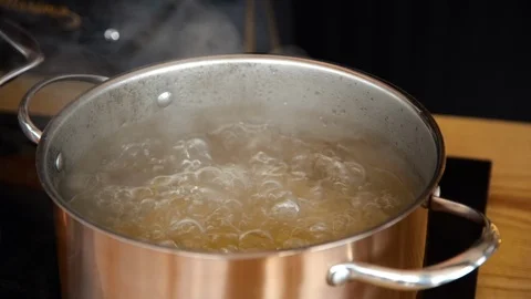 Close up slow motion shot of a copper pot full of boiling water and pasta Stock Footage 118895812