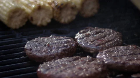 Close up slow motion shot of flames shooting up from juicy burgers on the grill 스톡 동영상 153332149