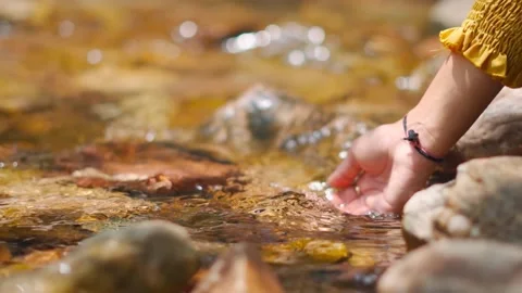Close up slow motion shot of girl hand slashing water of forest river. Autumn ba Stock Footage 208951069