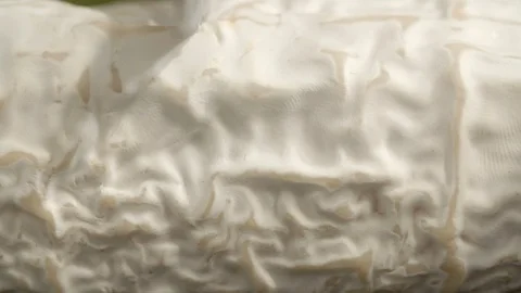 Close-up slow motion shot of knife cutting fresh goat cheese log in kitchen - Stock Footage 129206662