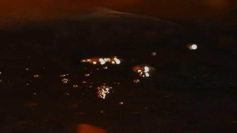 Close-up slow-motion shot of machine oil dripping into a steel drum, forming Vídeos de archivo 337926885