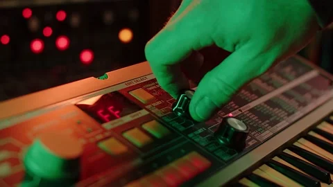 Close up slow motion shot of a man playing keys and turning knobs on a 動画素材 147237584