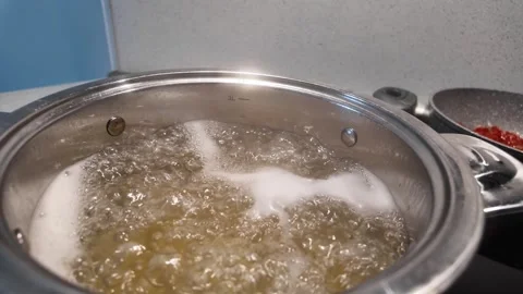 Close up slow motion shot of pasta boiling in a pot with bubbling hot water Stock Footage 344471234