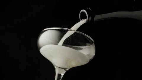 Close-up, slow motion shot: Pouring champagne into a glass on a black background Stockbeeldmateriaal 149835619