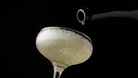 Close-up, slow motion shot: Pouring champagne into a glass on a black background Stockbeeldmateriaal 149835625