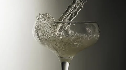Close-up, slow motion shot: Pouring champagne into a glass on a black background Stockbeeldmateriaal 149836043