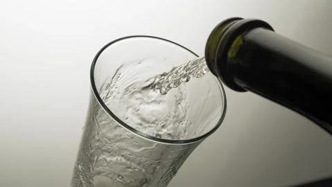 Close-up, slow motion shot: Pouring champagne into a glass on a black background Stockbeeldmateriaal 149836968