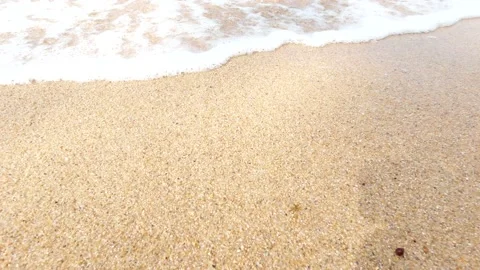 Close-up slow motion shot of sea waves breaking on sandy coastline. Low angle. Video stock 135214220