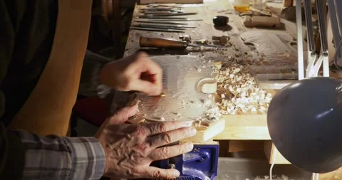 Close up Slow motion shot of violinmaker concentrating on carving, smoothing, Stock Footage 300538623