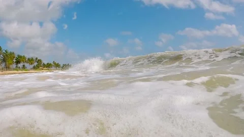 Close-up slow motion shot of a wave rolling over the camera on a bright sunny Stock Footage 205031728