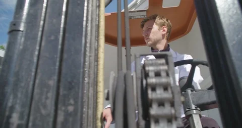 Close up slow motion shot, young man, worker operate, drive forklift, sunny day. Stock Footage 117293496