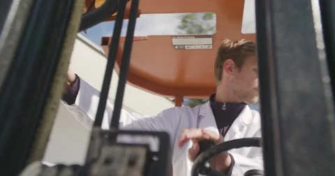 Close up slow motion shot, young man, worker operate, drive forklift, sunny day. Stock Footage 117294112