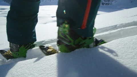 Close up slow motion of ski boots on skis in clear white snow on sunny day Stock Footage 129126688