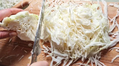 Close-up slow motion of slicing fresh cabbage on a wooden cutting board Stock Footage 341934913