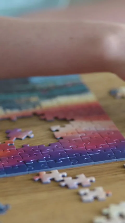 Close-up slow motion vertical view of young woman hands assembling puzzles. 스톡 동영상 302024827