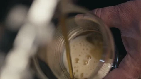Close-up slow motion video of beer being poured into a glass at a bar. Stock Footage 233190607