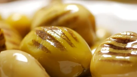 Close up slow motion video of grilled green olives shimmering with olive oil. 스톡 동영상 332258782