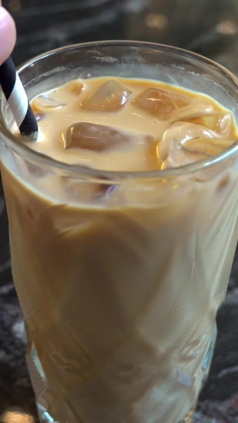 Close up slow motion video of hand stirring refreshing iced coffee with a s.. Stock Footage 339472269