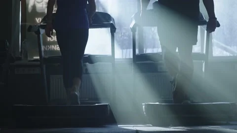 Close-up slow motion video of the legs of a man, a woman running treadmill gym Vídeos de archivo 236900745