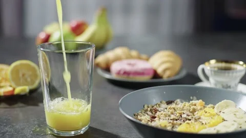 Close-up slow motion video of pouring orange juice for breakfast at home Stock Footage 236900985