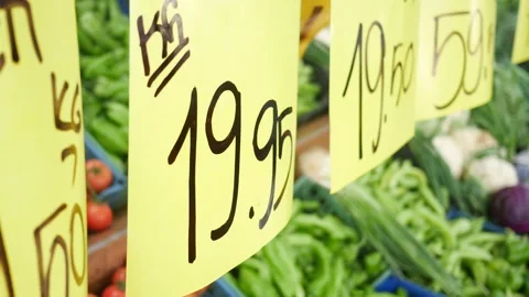 Close up slow motion video of price tags hanging on a fresh vegetables stal.. Stock Footage 332471963