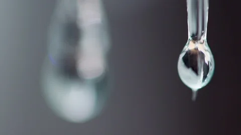 Close-up slow motion video of pure water drop dripping from small icicles Stock Footage 90637172