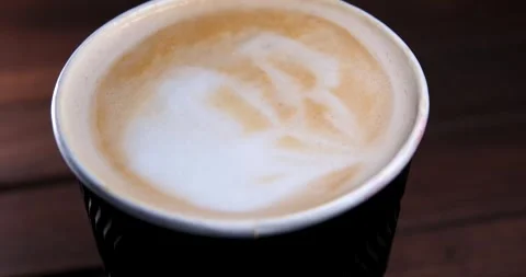 Close-up slow motion view of beautiful coffee latte art made from hot milk foam Stock Footage 274884408