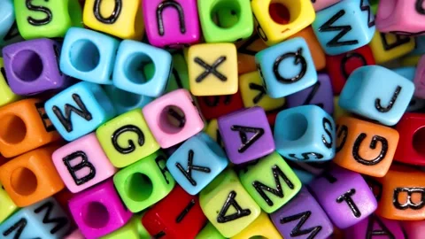 Close up slow motion view of colorful letter beads randomly placed. Stock Footage 326726665