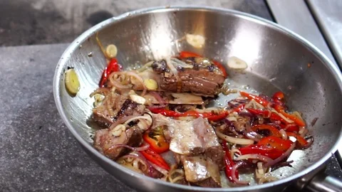 Close up slow motion view on delicious pork ribs meat slices simmering in steel Stock Footage 106812161