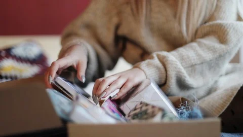 Close up slow motion view of female hands putting in gift box different presents Stock Footage 104562854