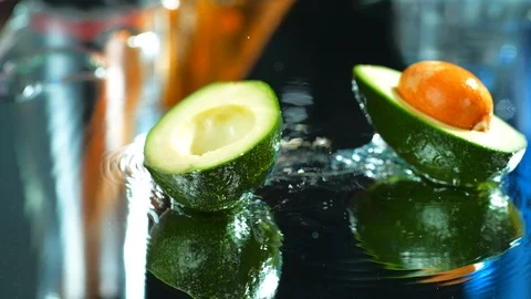 Close up slow motion view of fresh avocado falling  in water.  4k Stock Footage 114962380