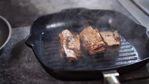 Close up slow motion view on hot steam coming up from black grill frying pan Stock Footage 105897013