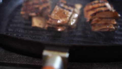 Close up slow motion view on tasty pork ribs in juicy sauce on black grill Stock Footage 105897459