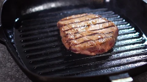 Close up slow motion view on thick piece of raw meat beef steak cooked on hot Stock Footage 105895368