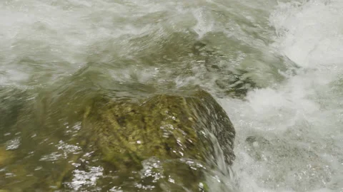 Close up slow motion of white water pouring over rocks in river in rapid Stock Footage 211644494