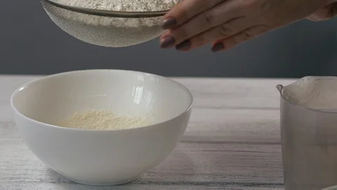 Close-up, Slow Motion, Woman's Hand Sifts the Flour Through a Sieve into a Bowl Stock Footage 102629479