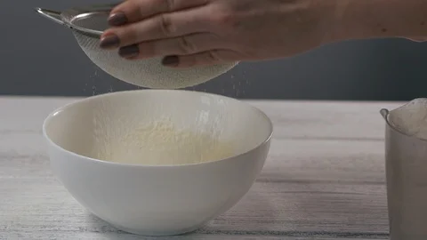 Close-up, Slow Motion, Woman's Hand Sifts the Flour into a White Bowl Stock Footage 102630825