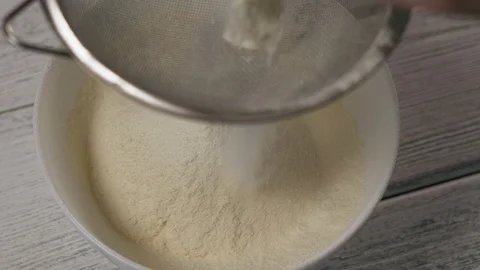 Close-up, Slow Motion, Woman's Hand Flour Flour Through a Sieve in a White Bowl Stock Footage 102631506