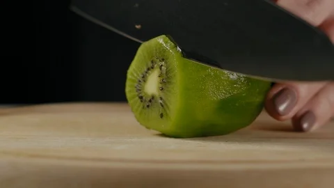 Close-Up, Slow Motion, Woman's Hand Slices Kiwi Stock Footage 103488759