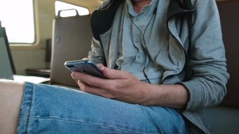 Close-up of the slow movement of men's hands using the phone on a train ride. Stock Footage 160944643