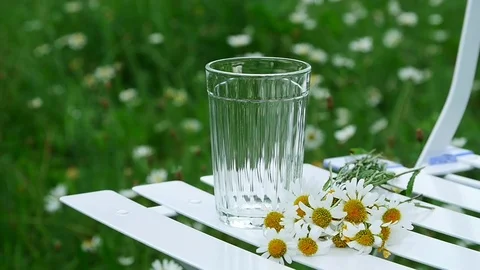 Close-up. Slowing down. Pour milk into a glass beaker. Beside lies a bouquet of Stock Footage