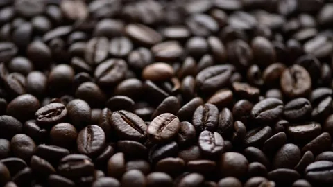 Close up of slowly rotating whole coffee beans background Stock Footage 310657131