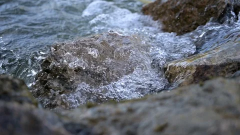Close-Up slowmoition recording of a river, which creates a wave on a stone Video stock 128956352
