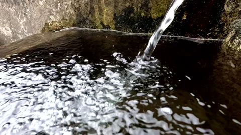 Close up slowmotion of a water jet that is making bubbles in the water Stock Footage 336871068