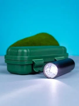 Close up of small and powerful handheld flashlight for travel on blue backgro Stock Photos