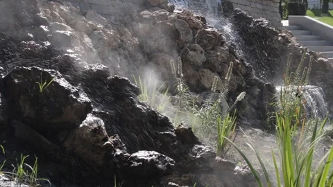 Close up of small artificial waterfall and green plants Stock Footage 94259209