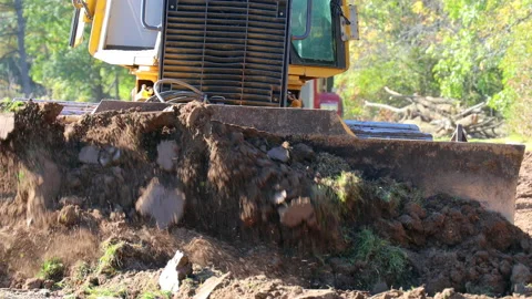Close up of  small bulldozer pushing soil for site preparation for new Vidéo 168729935