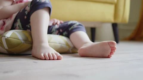 Close up small children legs in frame on wooden laminate on floor in large Stock Footage 196226773
