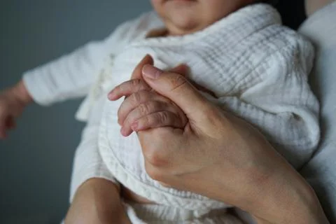 Close-up of a small childs hand gently touching or holding a parents hand, sy Stock Photos